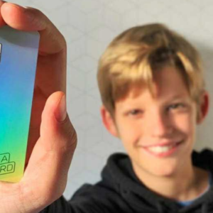 Un ado de 10 ans montre une carte de paiement Kard pour apprendre à gérer son argent de poche